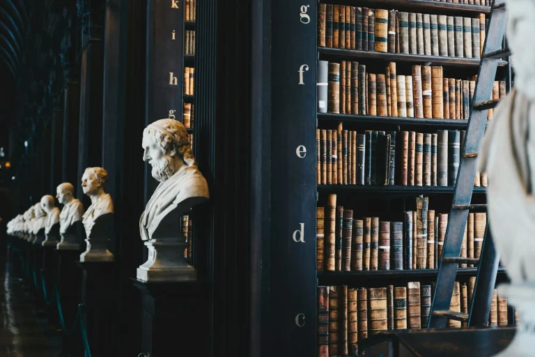 Long library hall with marble busts and shelves of old books